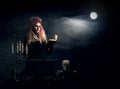 Beautiful witch making witchcraft on a smoky background. Halloween image. Royalty Free Stock Photo