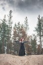 Beautiful witch with red hair standing on the hill Royalty Free Stock Photo