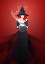 Beautiful witch wearing hat and black dress holding a magic cauldron casting a spell Royalty Free Stock Photo