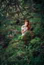 Beautiful woman alone in fairytale green forest