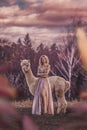 Beautiful woman with alpaca photoshoot portrait in forest