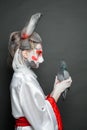 Beautiful woman in animal mask holding bird pigeon on black background. Halloween, Carnival and Cosplay concept Royalty Free Stock Photo