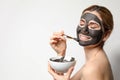 Beautiful woman applying black mask onto face. Space for text Royalty Free Stock Photo