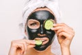 Beautiful woman applying black purifying charcoal facial mask. Face skin care Royalty Free Stock Photo