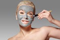 Beautiful Woman Applying Clay Facial Mask. Beauty Treatments. Spa Girl Apply Clay Facial mask with Beauty Brush