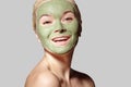 Beautiful Woman Applying Green Facial Mask. Beauty Treatments. Close-up Portrait of Spa Girl Apply Clay Facial mask