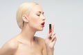 Beautiful woman applying lip gloss Royalty Free Stock Photo