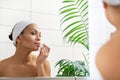 Beautiful latin american woman applying lipstick in front of the bathroom mirror Royalty Free Stock Photo