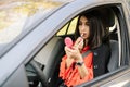 Beautiful woman applying makeup in a car Royalty Free Stock Photo