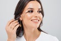 Beautiful woman applying mascara on her eyelashes - on white background Royalty Free Stock Photo