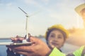 Beautiful woman architect, working on model of wind turbine an ecological construction project Royalty Free Stock Photo