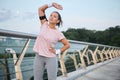 Young fitness woman working out outdoors on the bridge. Sports Women in sportswear stretching her body in the early morning at Royalty Free Stock Photo