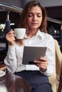 Beautiful woman attentively reading latest news on tablet