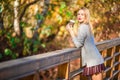 Fall concept - beautiful woman drinking coffee in autumn park under fall foliage Royalty Free Stock Photo