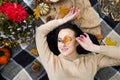 Beautiful woman on autumn picnic with flowers, fall leaves and pumpkin, thanksgiving holiday Royalty Free Stock Photo