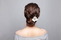 Beautiful woman back and head with perfect hairdo and white flower on white background Royalty Free Stock Photo