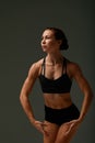 beautiful woman ballet dancer in black swimsuit posing on light grey studio background. Animal instinct