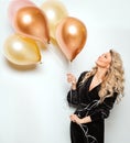 Beautiful Woman with Balloons over White background side view. Birthday Party Time. Happy smiling Blonde Model with Curly Hair Royalty Free Stock Photo