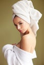 Beautiful woman in bath robe with a towel on her head looking thoughtfully