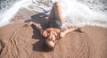 Beautiful woman in a bathing suit lying on the sand by the sea top view Royalty Free Stock Photo