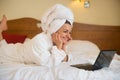 Beautiful woman in bathrobe with laptop Royalty Free Stock Photo