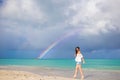 Beautiful happy woman on the beach with beautiful rainbow over the sea Royalty Free Stock Photo