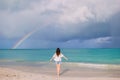 Beautiful happy woman on the beach with beautiful rainbow over the sea Royalty Free Stock Photo