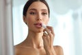 Beautiful Woman With Beauty Face Applies Balm On Lips. Skin Care Royalty Free Stock Photo