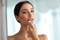 Beautiful Woman With Beauty Face Applies Balm On Lips. Skin Care Royalty Free Stock Photo