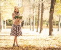Beautiful woman being alone in the autumn park with a book