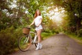 A beautiful woman with a bike in the park. Rent transport for the day. Sunny summer, spring. Fabulous art processing