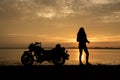 Beautiful Woman biker enjoying sunset, female riding motorcycle. motorbike driver traveling the world, Relaxing after long trip, f Royalty Free Stock Photo