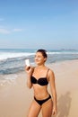 Beautiful Woman in Bikini Applying Sun Cream on Tanned  Shoulder. Sun Protection. Skin and Body Care. Girl Using Sunscreen to Skin Royalty Free Stock Photo