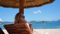 Beautiful woman in a bikini enjoys the tropical sun for a tan on a sunchair Royalty Free Stock Photo