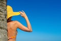 Beautiful woman in bikini and Sunhat standing with hands raised