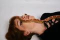 Beautiful woman in black bodywear and snake. Ginger model girl with fashion perfect make up Royalty Free Stock Photo