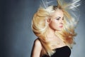 Beautiful woman in black dress. blond girl.healthy hair.Beauty salon.flying hair Royalty Free Stock Photo