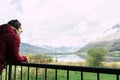 Beautiful woman in a black dress smiling at sunset on a background of mountains and a lake. Laughing girl in a balcony with cloudy Royalty Free Stock Photo