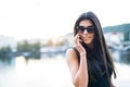 Beautiful woman in black dress standing by a river in city of Prague, making a phone call. Royalty Free Stock Photo