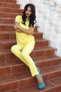 Beautiful woman with black hair in elegant yellow suit