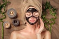Beautiful woman with black purifying black charcoal mask on her face. Beauty model girl with black facial peel-off mask Royalty Free Stock Photo