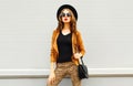 Beautiful woman in black round hat, sunglasses, brown jacket Royalty Free Stock Photo