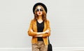 Beautiful woman in black round hat, sunglasses, brown jacket wall Royalty Free Stock Photo