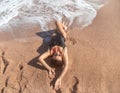 Beautiful woman in a bathing suit lying on the sand by the sea top view Royalty Free Stock Photo