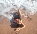 Beautiful woman in a bathing suit lying on the sand by the sea top view Royalty Free Stock Photo