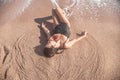 Beautiful woman in a bathing suit lying on the sand by the sea top view Royalty Free Stock Photo