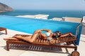 Beautiful woman with blond hair in elegant bikini posing near swimming pool with sea view Royalty Free Stock Photo