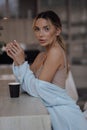 beautiful woman with blond hair in elegant cosy home clothes, drinking coffee in the kitchen