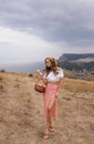 Beautiful woman with blond hair in elegant dress having picnic with mountains view Royalty Free Stock Photo