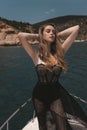 beautiful woman with blond hair in luxurious black dress relaxing on the yacht in the Mediterranean sea Royalty Free Stock Photo